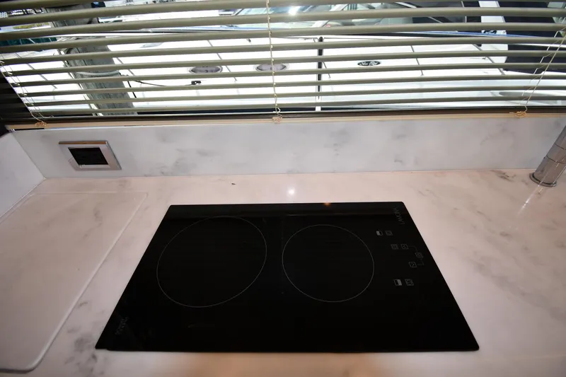 Slide: The Image of Modern kitchen countertop with induction cooktop on 2024 Fairline G50 Targa yacht. - 58