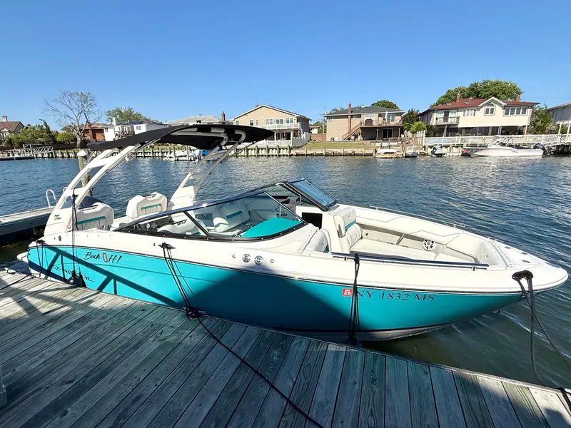 Slide: The Image of 2022 Regal LX4 boat docked, blue and white, with cover. - 2