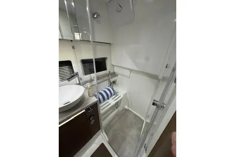 Slide: The Image of 2021 Jeanneau Leader 12.5 WA boat bathroom with modern fixtures and striped towel. - 30
