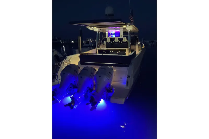 Slide: The Image of 2021 Jeanneau Leader 12.5 WA boat with illuminated engines at night. - 13
