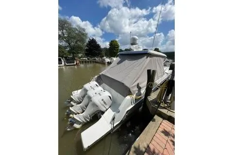 Slide: The Image of 2021 Jeanneau Leader 12.5 WA boat docked with covered deck and triple outboard engines. - 6