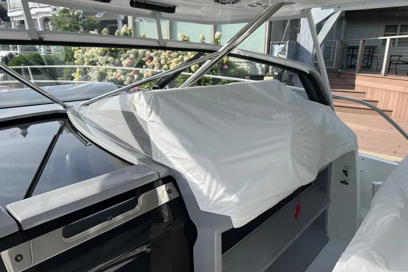 Slide: The Image of 2021 Jeanneau Leader 12.5 WA boat interior with protective cover, showcasing sleek design. - 12