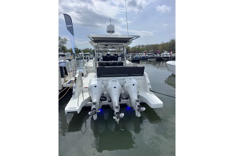 Slide: The Image of 2021 Jeanneau Leader 12.5 WA boat with triple outboard engines docked at marina. - 5