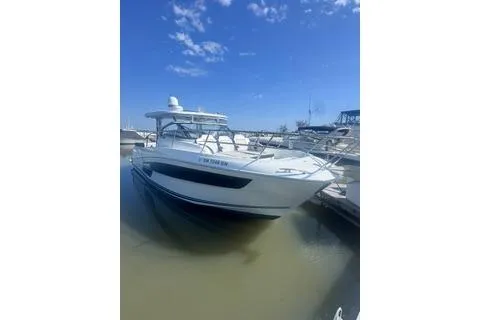 Slide: The Image of 2021 Jeanneau Leader 12.5 WA boat docked on calm water under a clear blue sky. - 2