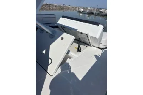 Slide: The Image of 2021 Jeanneau Leader 12.5 WA boat with open storage compartments, docked by calm waters. - 45