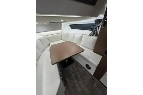 Slide: The Image of Interior of 2021 Jeanneau Leader 12.5 WA with white seating and wooden table. - 33