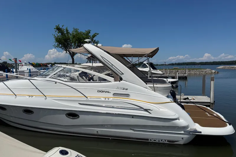 Slide: The Image of 2001 Doral 330se boat docked at a marina under a clear blue sky. - 2