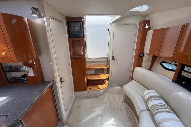 Slide: The Image of Interior of a 2001 Doral 330se boat featuring wood cabinetry and a cozy seating area. - 29