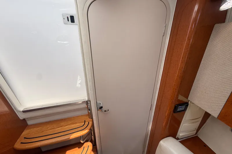Slide: The Image of Interior of a 2001 Doral 330se boat, featuring wooden accents and a closed door. - 35