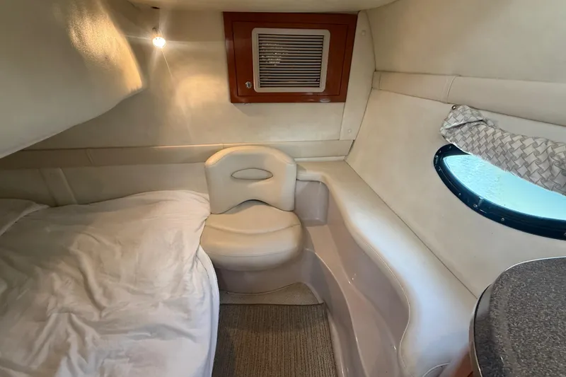 Slide: The Image of Interior cabin of a 2001 Doral 330se boat, featuring cozy seating and a small window. - 37