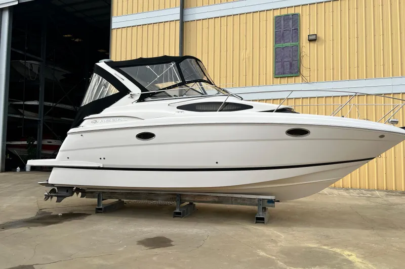 The Image of 2015 Regal 30 Express boat in front of yellow warehouse. - 1