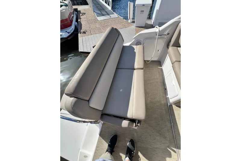 Slide: The Image of 2015 Regal 30 Express boat interior with beige seating and dock view. - 10