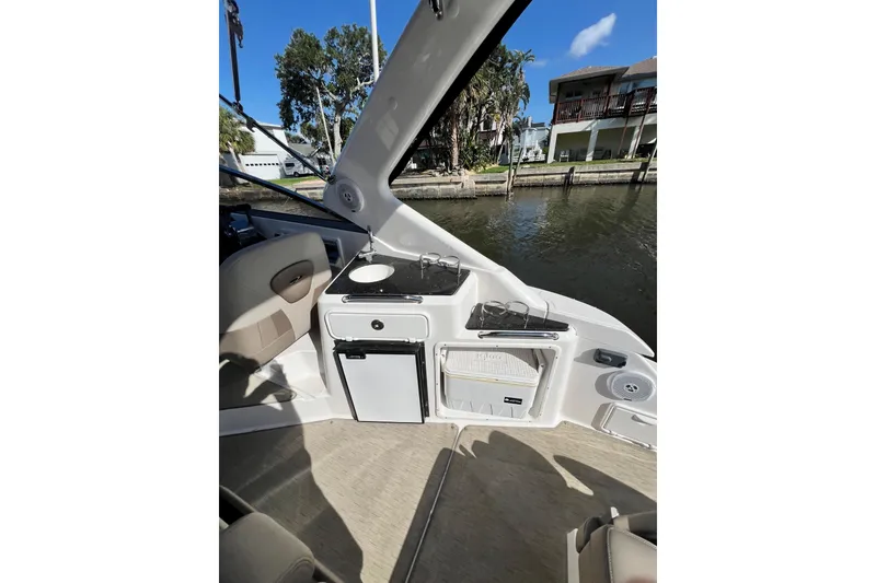 Slide: The Image of 2015 Regal 30 Express boat interior with kitchenette and seating by the water. - 12