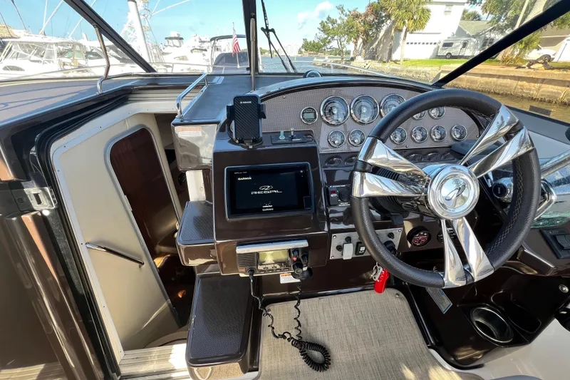 Slide: The Image of Helm of 2015 Regal 30 Express boat with modern controls and sleek steering wheel. - 13