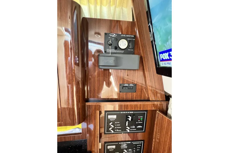Slide: The Image of Control panel inside a 2015 Regal 30 Express boat, featuring wood finish and electronic displays. - 19