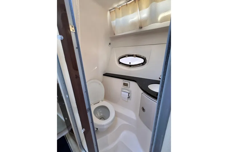 Slide: The Image of Bathroom interior of 2015 Regal 30 Express boat with toilet and porthole window. - 20