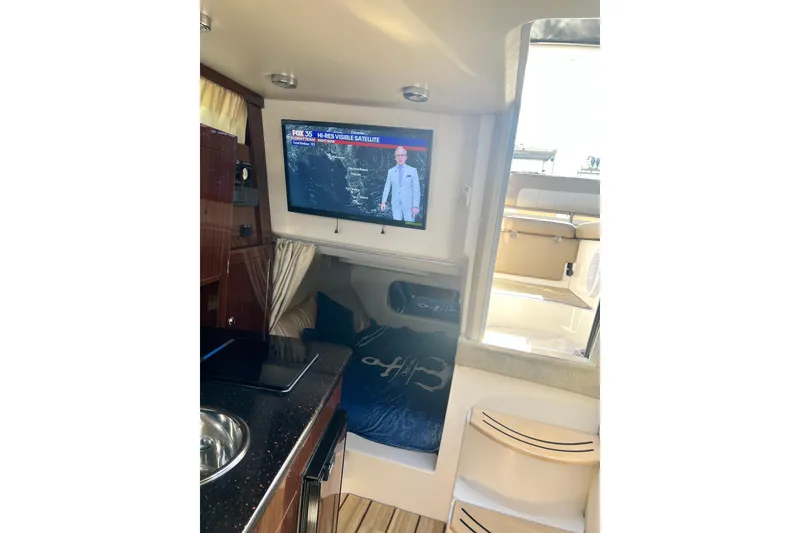 Slide: The Image of Interior of 2015 Regal 30 Express boat with TV and cozy seating area. - 22