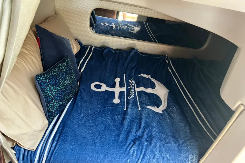 Slide: The Image of Cozy cabin interior of 2015 Regal 30 Express with nautical-themed bedding. - 23