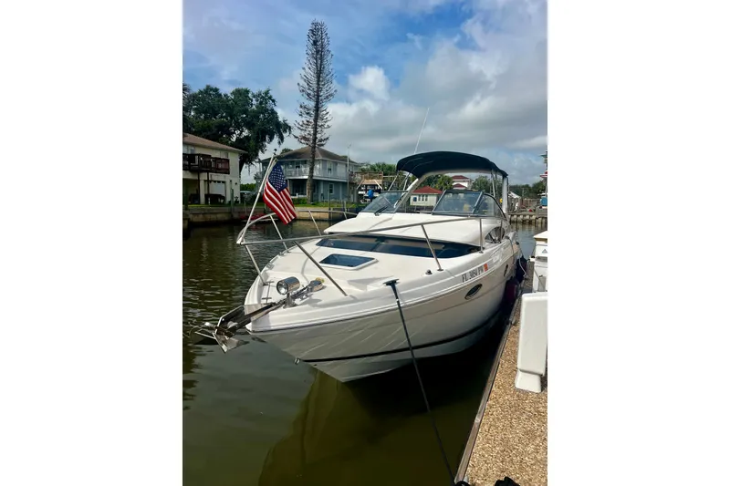 The Image of 2015 Regal 30 Express boat docked, featuring sleek design and American flag. - 0