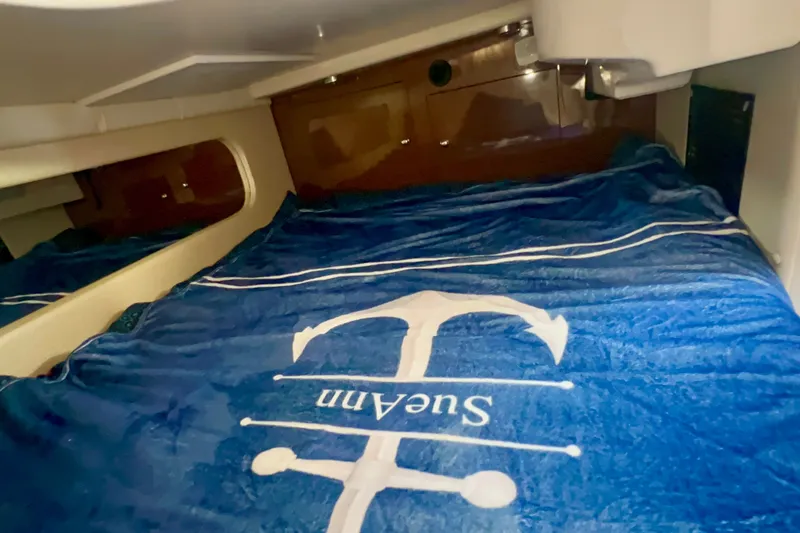 Slide: The Image of Cozy cabin interior of 2015 Regal 30 Express boat with nautical-themed bedding. - 31