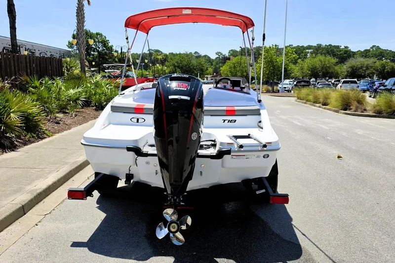 Slide: The Image of 2026 Tahoe T18 boat with outboard motor and red canopy, parked on a sunny street. - 4