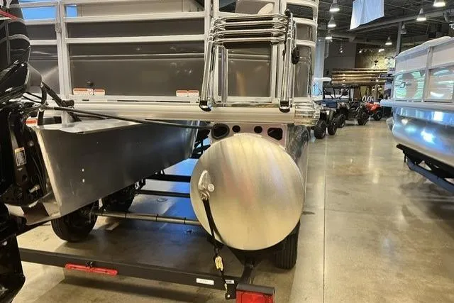 Slide: The Image of 2026 Sun Tracker Fishin' Barge 20 DLX pontoon boat displayed in a showroom. - 4