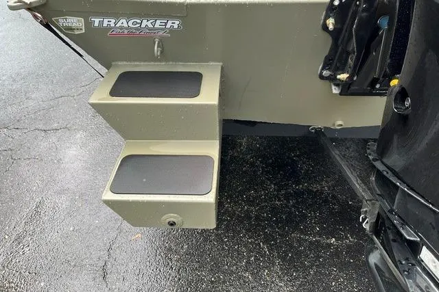 Slide: The Image of 2026 Tracker Grizzly 1654 T Sportsman boat with rear step detail on wet pavement. - 15