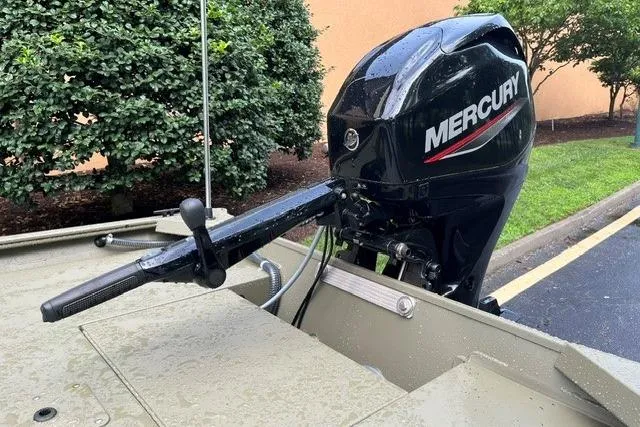 Slide: The Image of 2026 Tracker Grizzly 1654 T Sportsman boat with Mercury outboard motor, parked outdoors. - 4