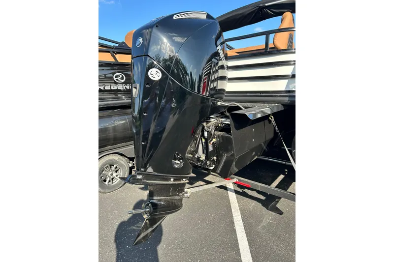 Slide: The Image of 2026 Ranger 223FC boat with a sleek black outboard motor in a parking lot. - 5