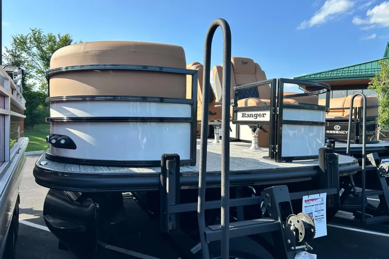 Slide: The Image of 2026 Ranger 223FC pontoon boat with tan seating, displayed outdoors under a clear sky. - 1