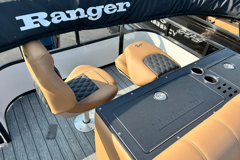 Slide: The Image of Interior of 2026 Ranger 223FC boat with tan and black seating and console. - 15