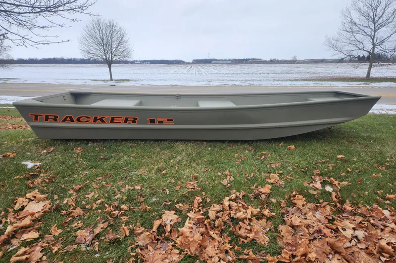The Image of 2026 Tracker Grizzly 12 Jon boat on grass, autumn leaves scattered, overcast sky. - 0