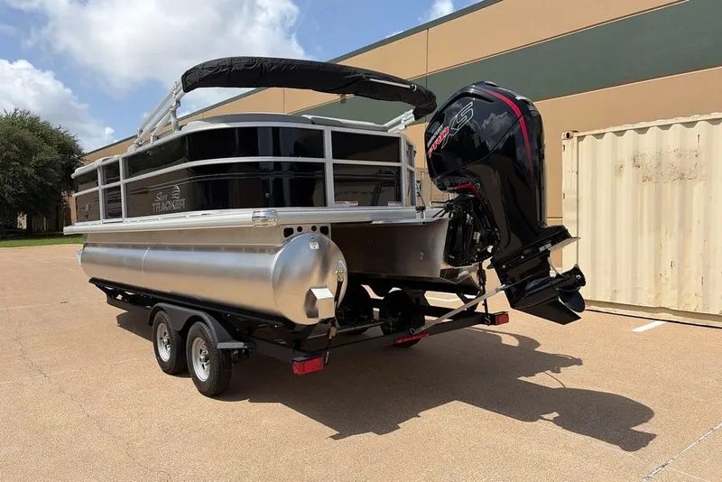 Slide: The Image of 2026 Sun Tracker Party Barge 20 DLX pontoon boat on trailer, parked outdoors. - 4