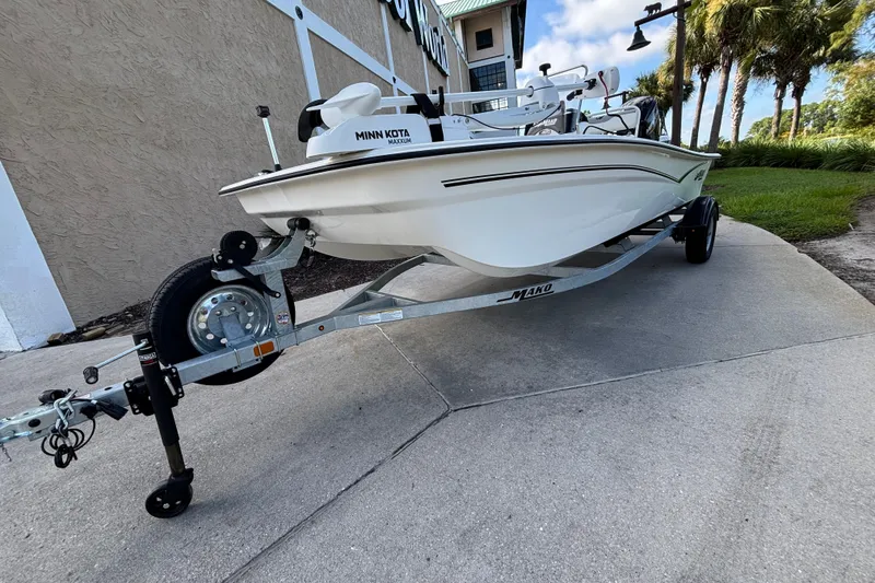 Slide: The Image of 2026 Mako Pro Skiff 17 CC boat on trailer, parked outdoors near building. - 7