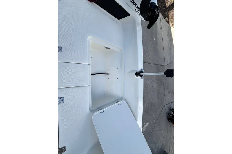 Slide: The Image of 2026 Mako Pro Skiff 17 CC boat interior storage compartment and trolling motor. - 9