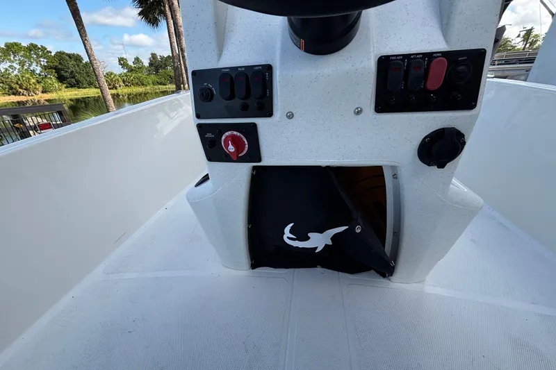 Slide: The Image of Control panel of a 2026 Mako Pro Skiff 17 CC boat with switches and storage. - 13