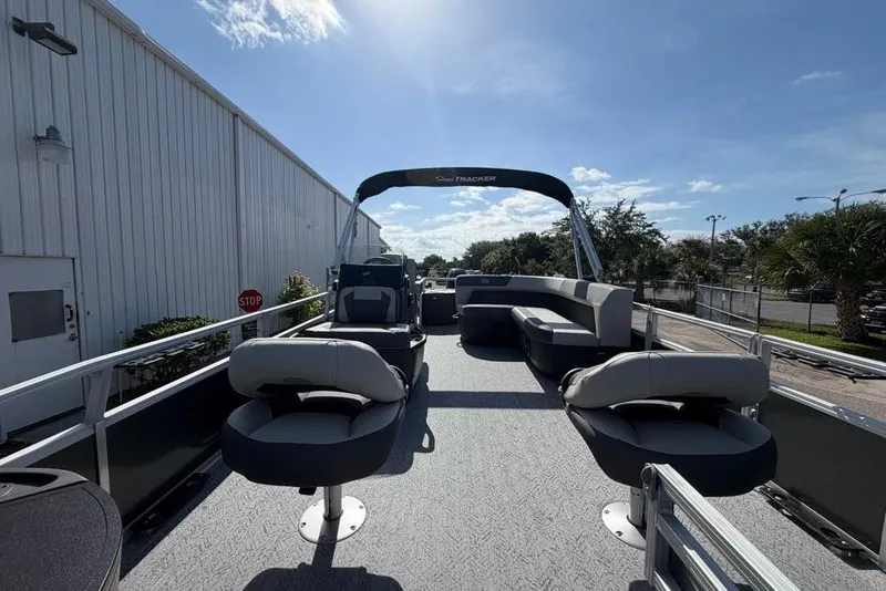 Slide: The Image of 2026 Sun Tracker Bass Buggy 18 DLX pontoon boat with seating, docked outdoors. - 5