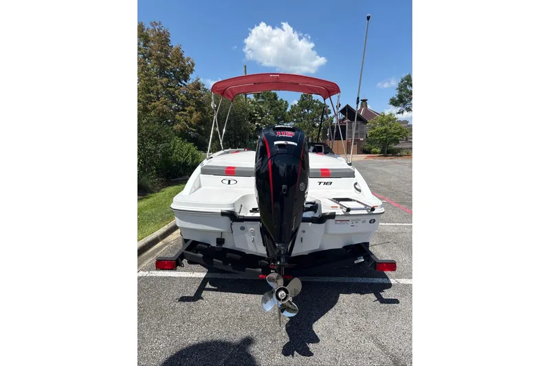 Slide: The Image of 2026 Tahoe T18 boat with outboard motor in a parking lot. - 2