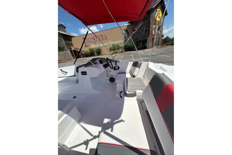 Slide: The Image of 2026 Tahoe T18 boat interior with red canopy, parked near Louisiana Sportsman's Paradise. - 5
