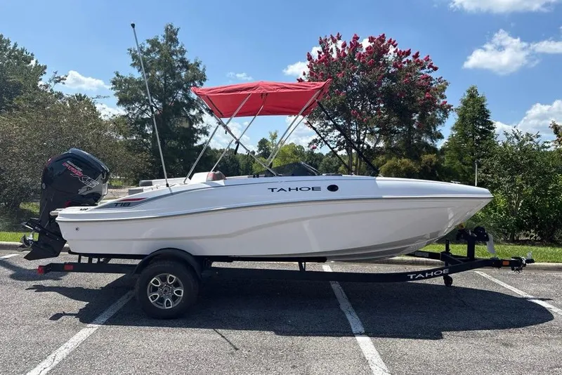 The Image of 2026 Tahoe T18 boat with red canopy on trailer, parked in sunny outdoor setting. - 0