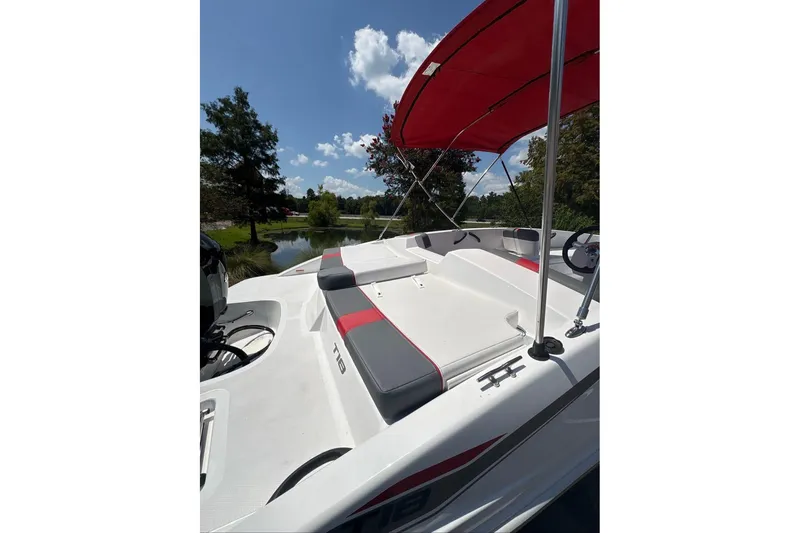 Slide: The Image of 2026 Tahoe T18 boat with red canopy, sleek seating, and scenic lake backdrop. - 7