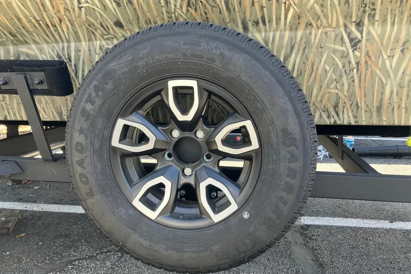 Slide: The Image of Trailer wheel of 2026 Tracker Grizzly 1756 T Marsh with camo design. - 13