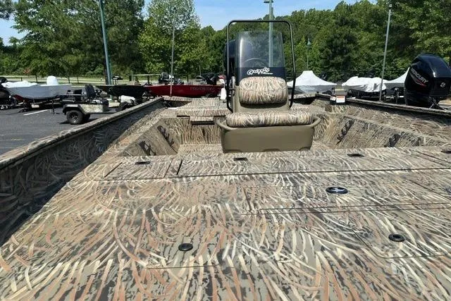 Slide: The Image of 2026 Tracker Grizzly 2072 CC boat with camouflage design, parked outdoors. - 3