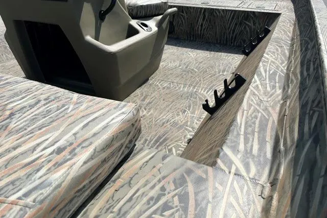 Slide: The Image of 2026 Tracker Grizzly 2072 CC boat interior with camouflage design and rod holders. - 4