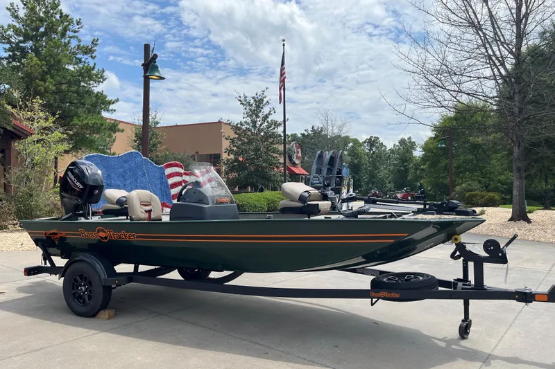 The Image of 2026 Tracker Bass Tracker Classic Limited boat on trailer, outdoors with trees and building background. - 0