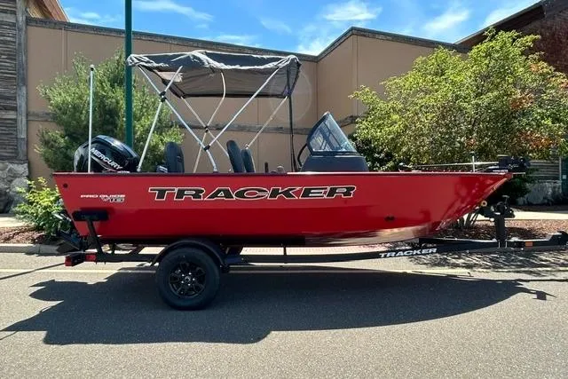 The Image of 2026 Tracker Pro Guide V-16 WT boat, red exterior, parked outdoors on a sunny day. - 0