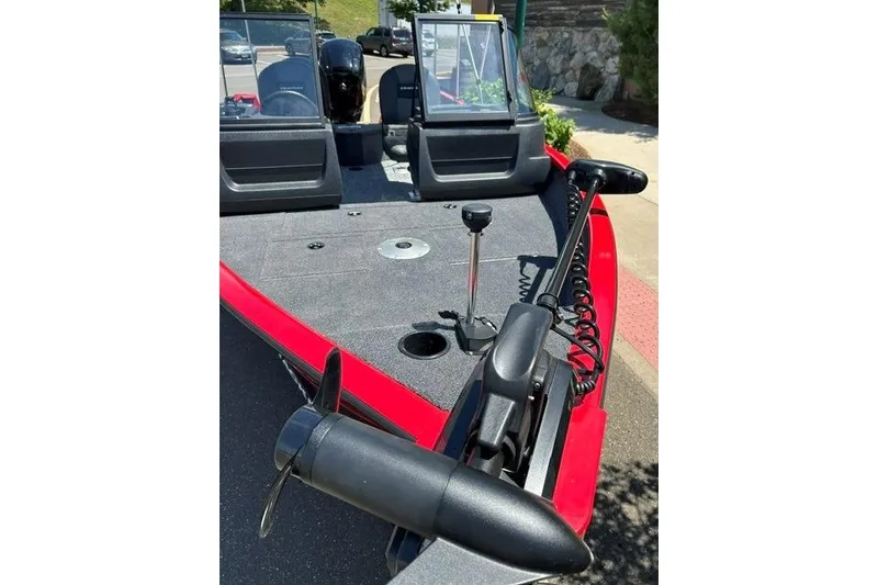 Slide: The Image of 2026 Tracker Pro Guide V-16 WT boat with trolling motor and windshield, parked outdoors. - 2