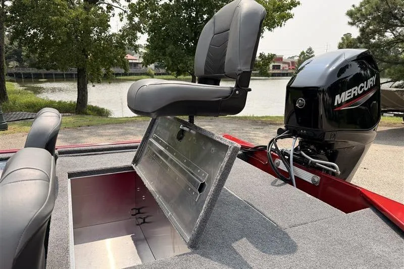 Slide: The Image of 2026 Tracker Bass Tracker Classic XL boat with open storage compartment and Mercury engine by a lake. - 13