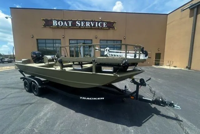 The Image of 2026 Tracker Grizzly 2072 CC Sportsman boat on trailer outside service center. - 0