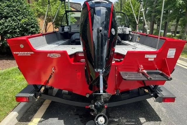 Slide: The Image of Red 2026 Tracker Pro Guide V-175 Combo boat with powerful outboard motor, parked outdoors. - 3